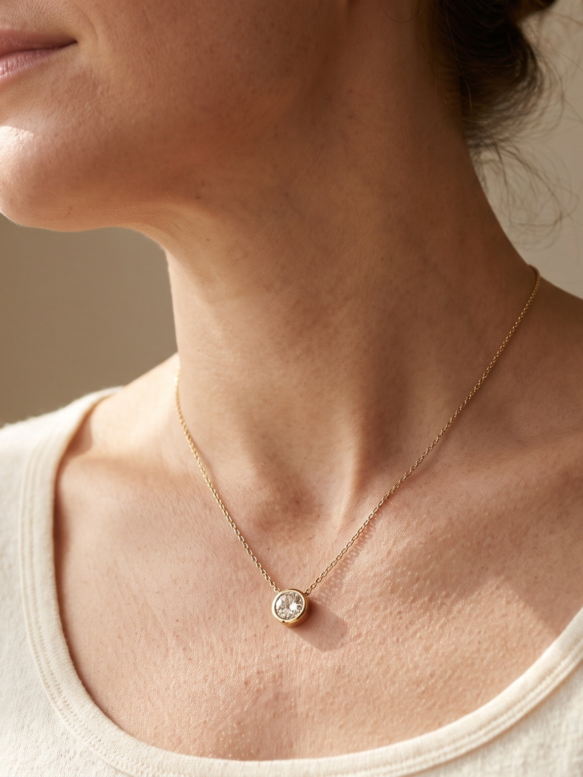 Woman wearing a delicate diamond pendant necklace