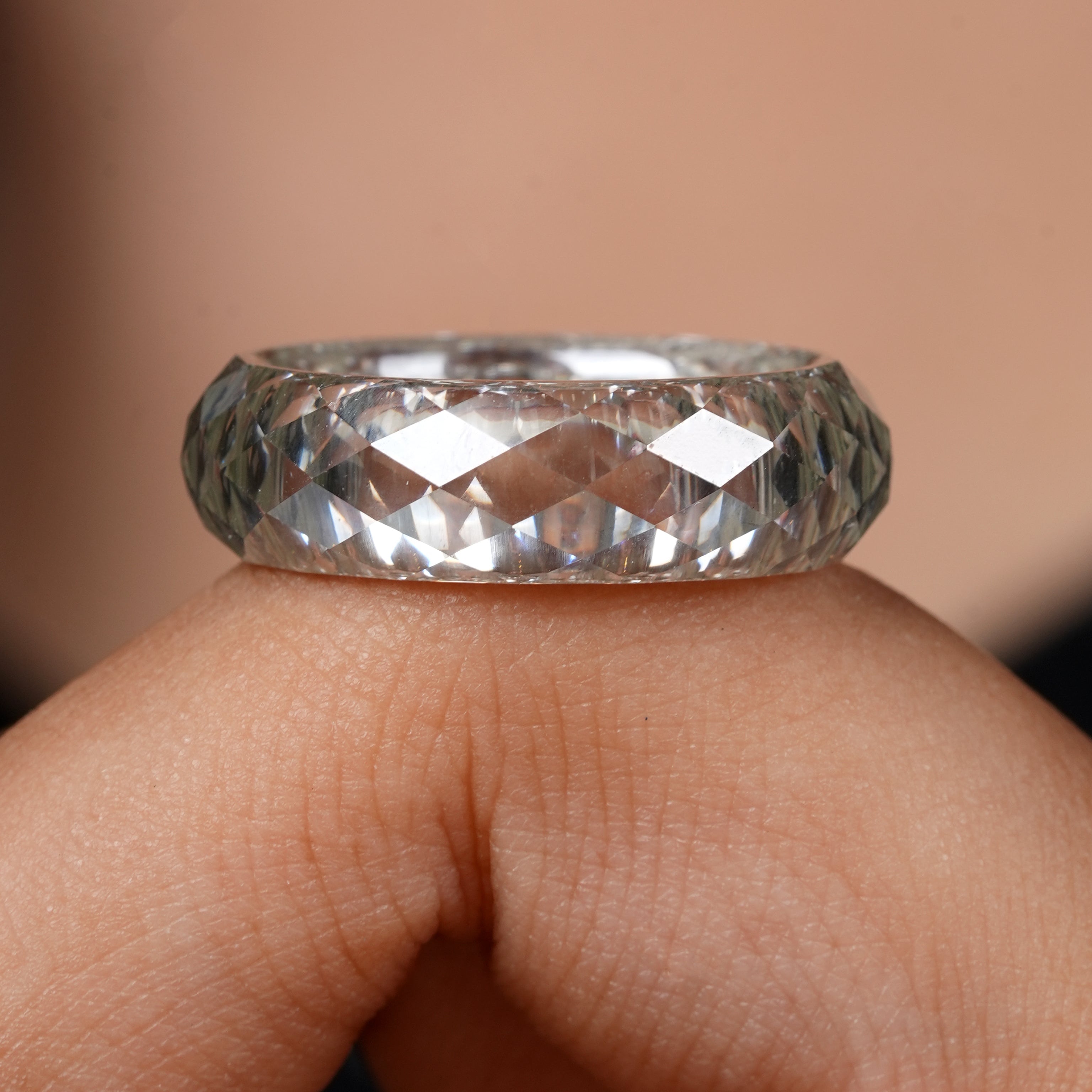 Close-up of a hand wearing a diamond ring with a blurred background