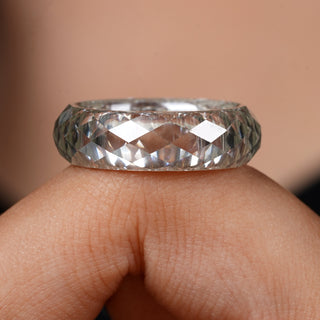 Close-up of a hand wearing a diamond ring with a blurred background