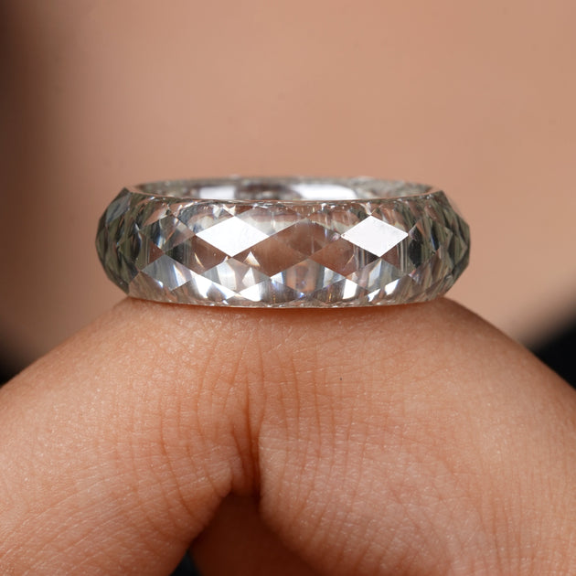 Close-up of a hand wearing a diamond ring with a blurred background