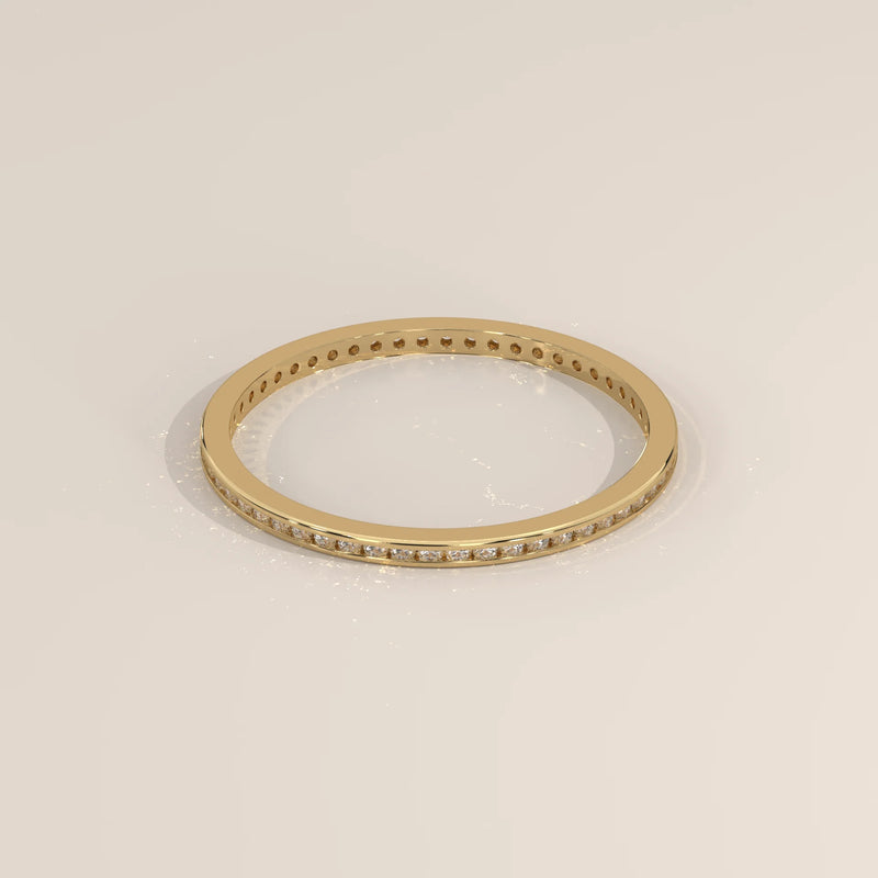 Yellow gold eternity ring with round lab grown diamonds channel set flush in a flat band, viewed from overhead.