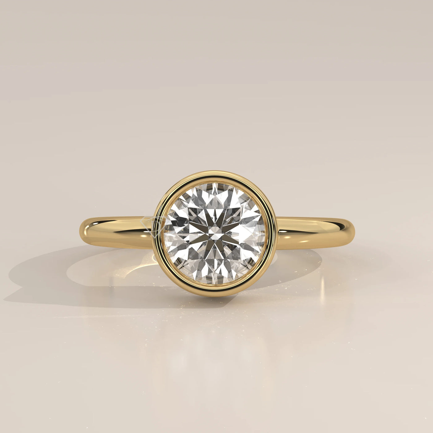 A classic 14k yellow gold ring with a bezel-set round diamond.