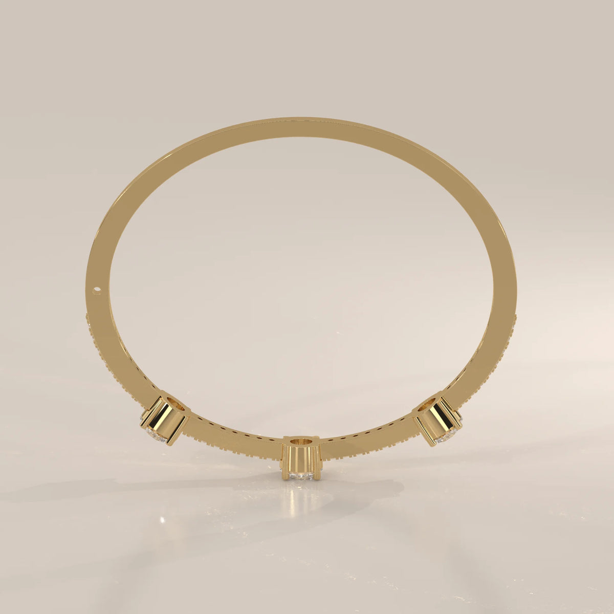 A delicate gold bangle bracelet with three prominent diamonds and a pave band.