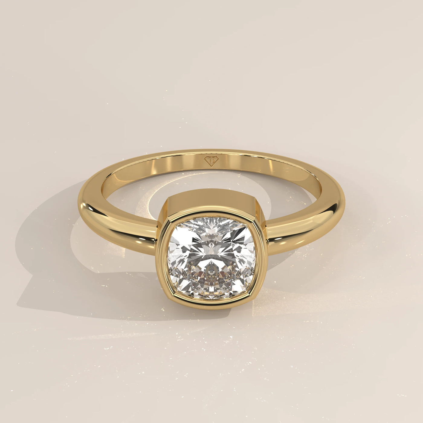A 14k yellow gold ring with a cushion-cut diamond set in a bezel setting.