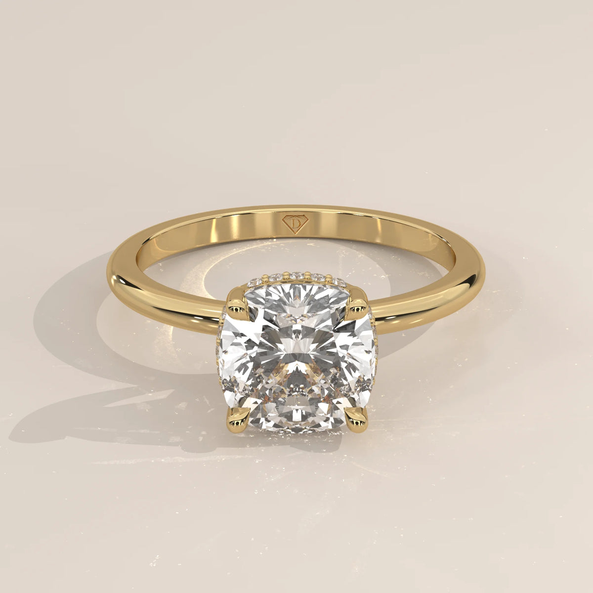 A yellow gold ring with a bezel-set cushion-cut diamond.