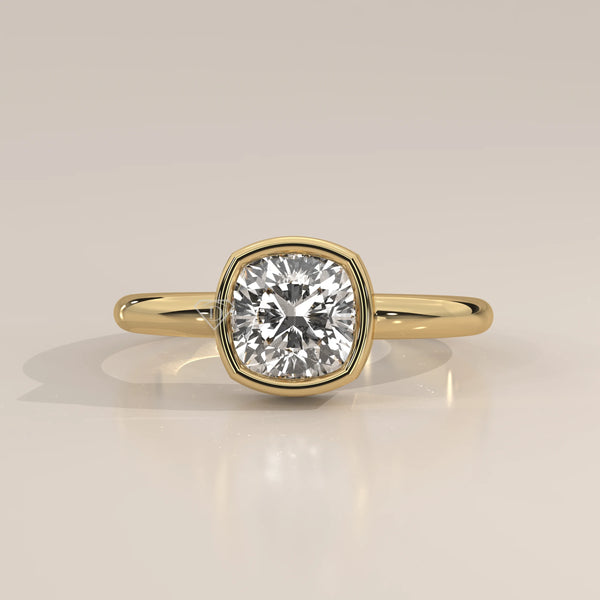 Gold ring with a cushion-cut diamond in a bezel setting.