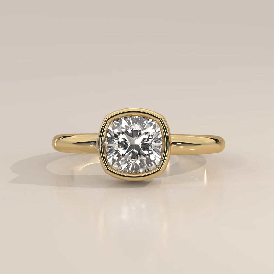 Gold ring with a cushion-cut diamond in a bezel setting.
