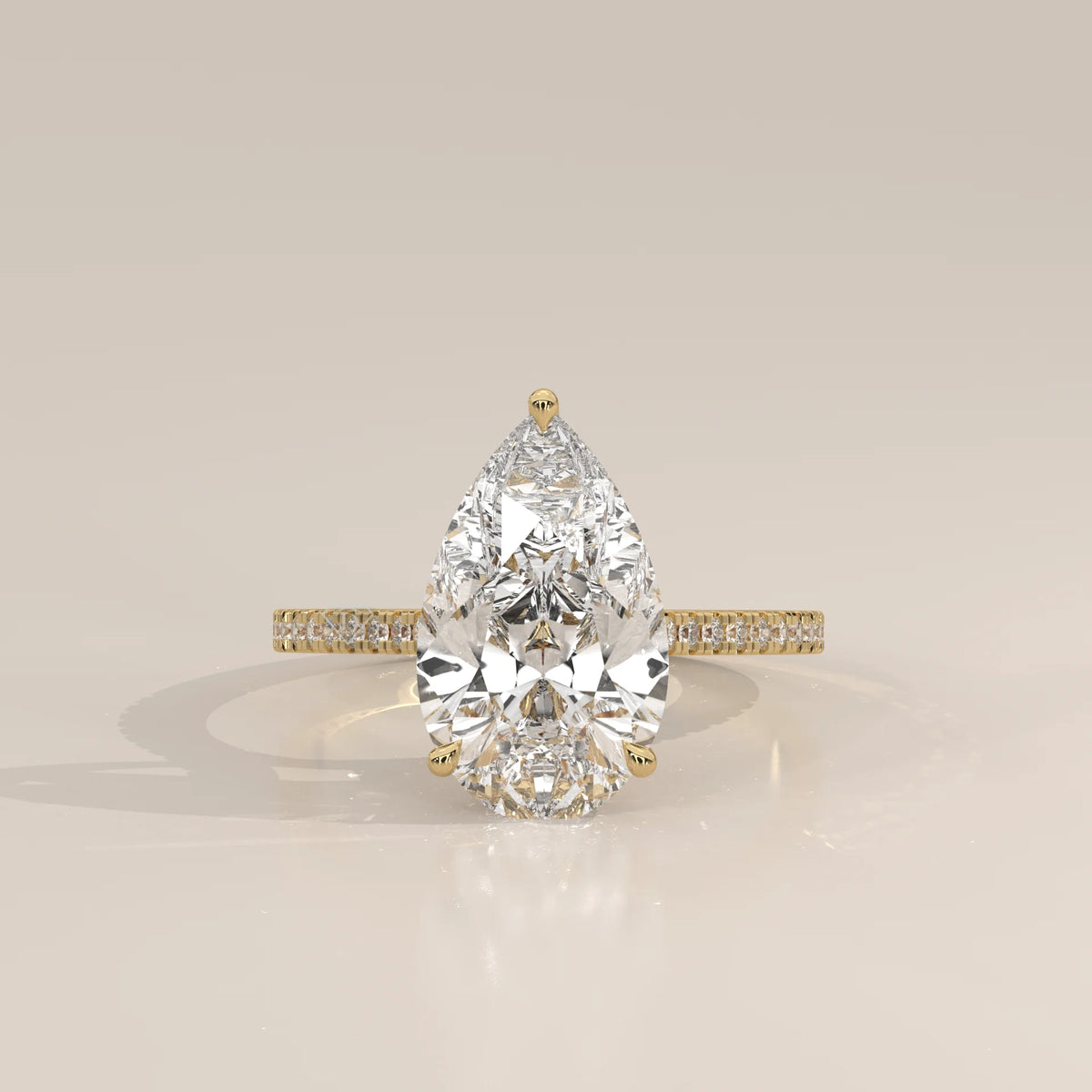 Cygri 5 Carat Pear Lab Grown Diamond Ring, Hidden Halo Pave Band in yellow gold, photographed head-on.