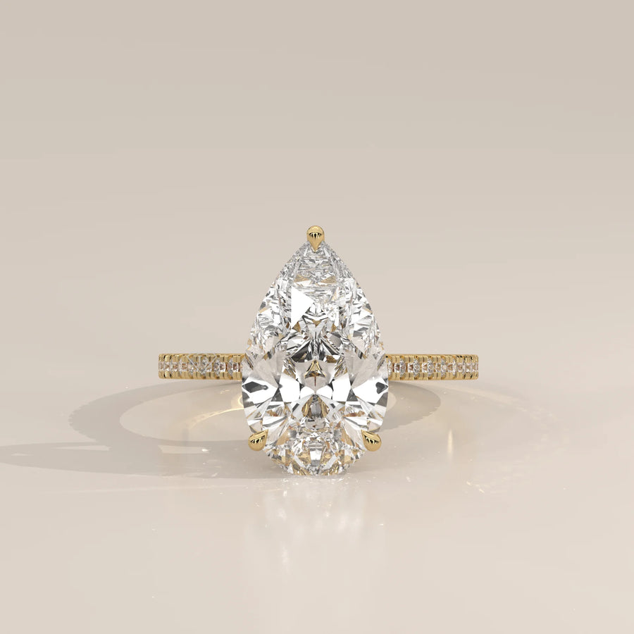 Cygri 5 Carat Pear Lab Grown Diamond Ring, Hidden Halo Pave Band in yellow gold, photographed head-on.