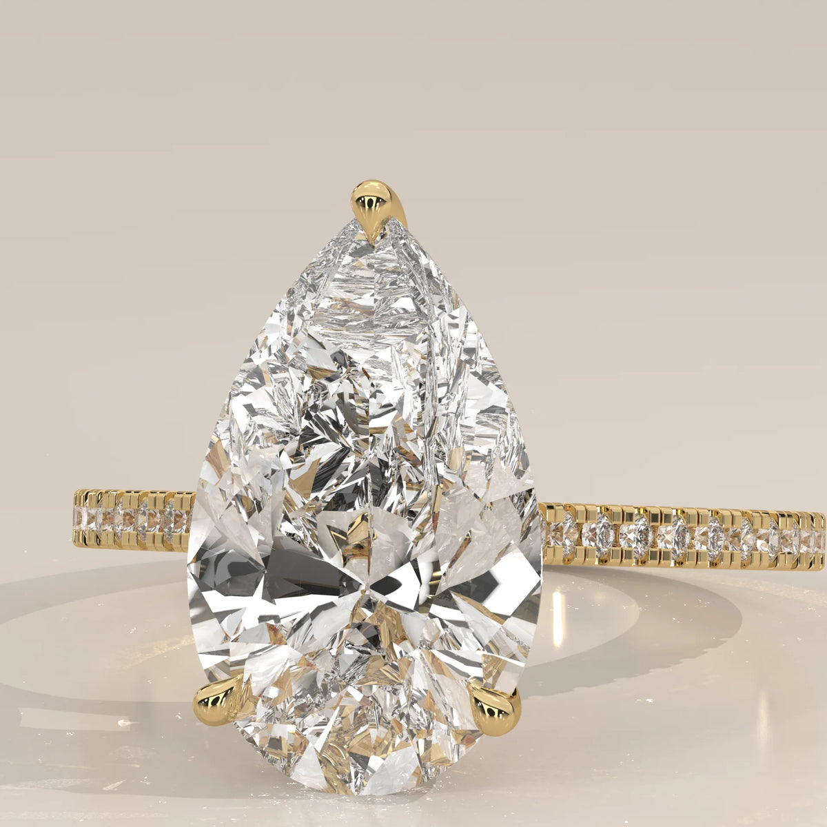 Cygri 5 Carat Pear Lab Grown Diamond Ring, Hidden Halo Pave Band in yellow gold, front view on a plain background.
