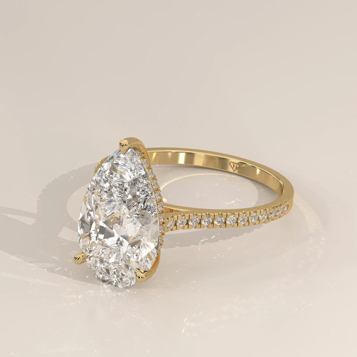 Cygri 5 Carat Pear Lab Grown Diamond Ring, Hidden Halo Pave Band in yellow gold, shown from the side.