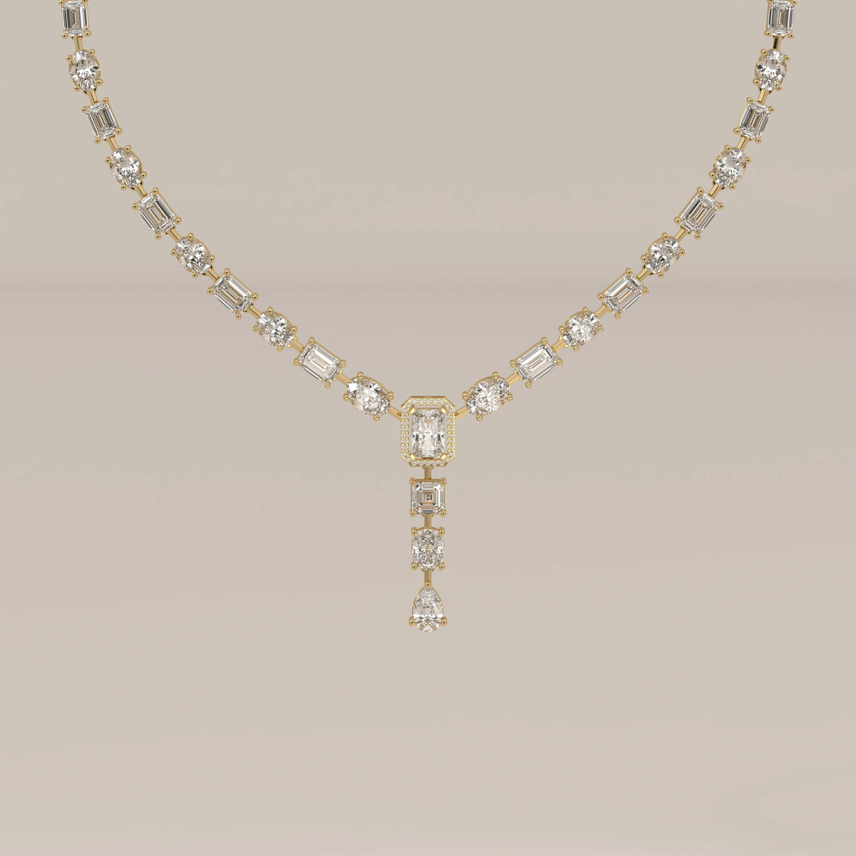 An emerald cut halo y-drop lab grown diamond necklace in yellow gold, shown from the front.