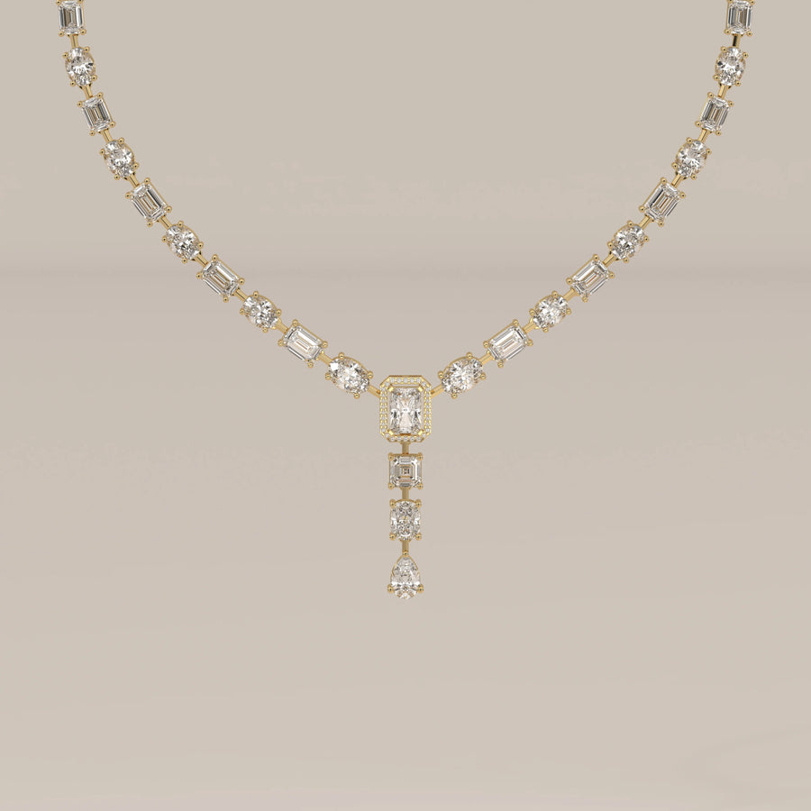 An emerald cut halo y-drop lab grown diamond necklace in yellow gold, shown from the front.