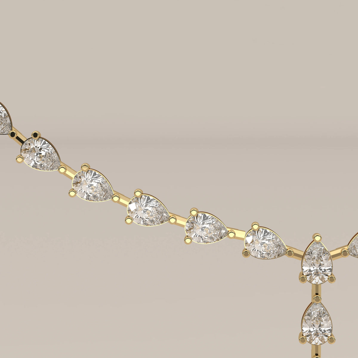 A pear shape lab grown diamond drop necklace in yellow gold, shown in close-up.