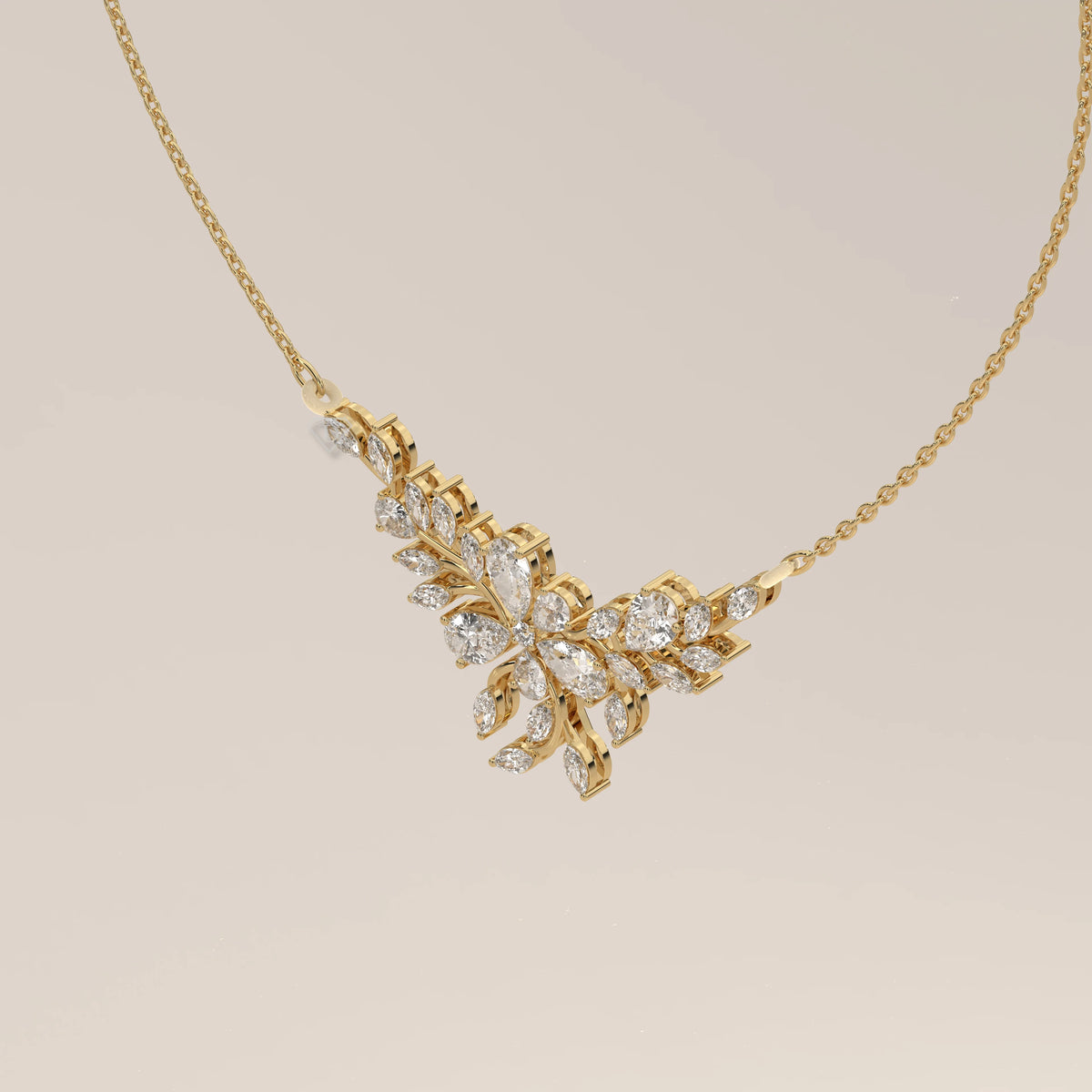 A marquise and pear lab grown diamond leaf necklace in yellow gold, shown at an angle.