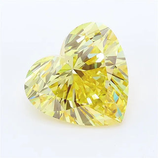 Heart cut intense yellow lab grown diamond with brilliant facets on a white background.