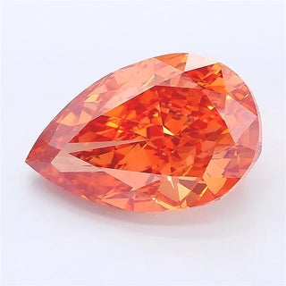 Pear cut orangy brown lab grown diamond with faceted surface on a white background.