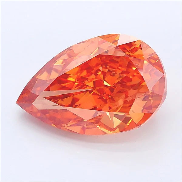 Pear cut orangy brown lab grown diamond with faceted surface on a white background.