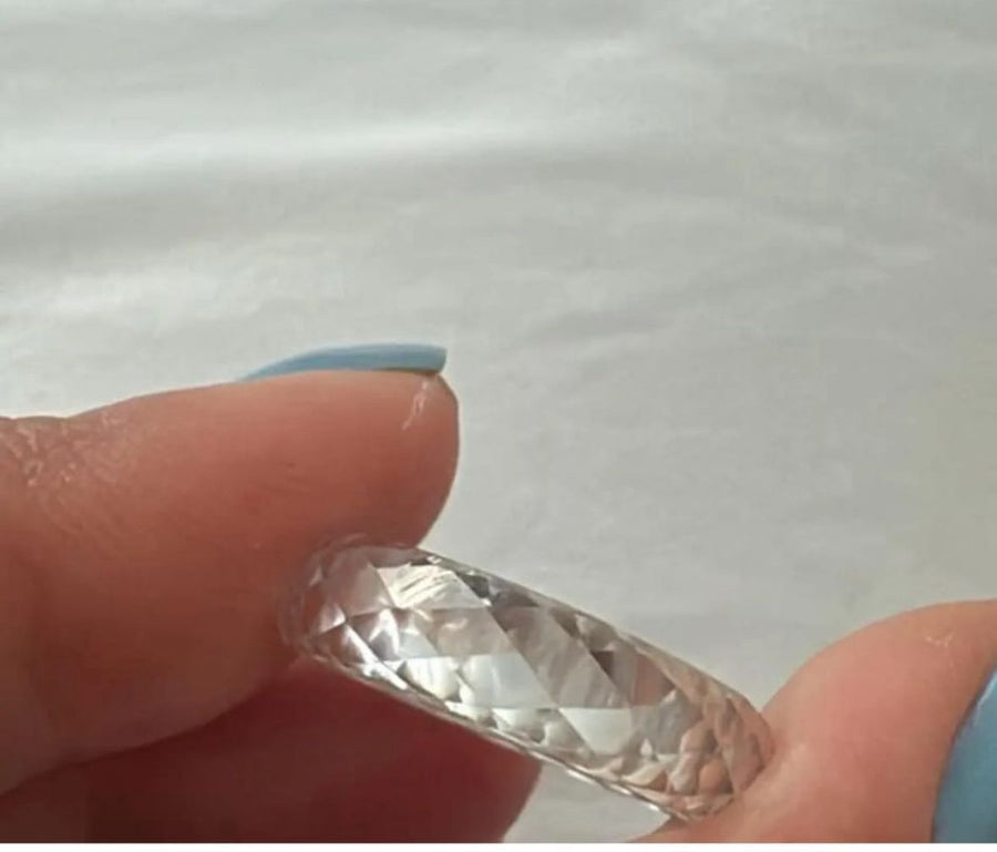 Close up of a faceted crushed ice diamond band held by a Driona Jewels customer