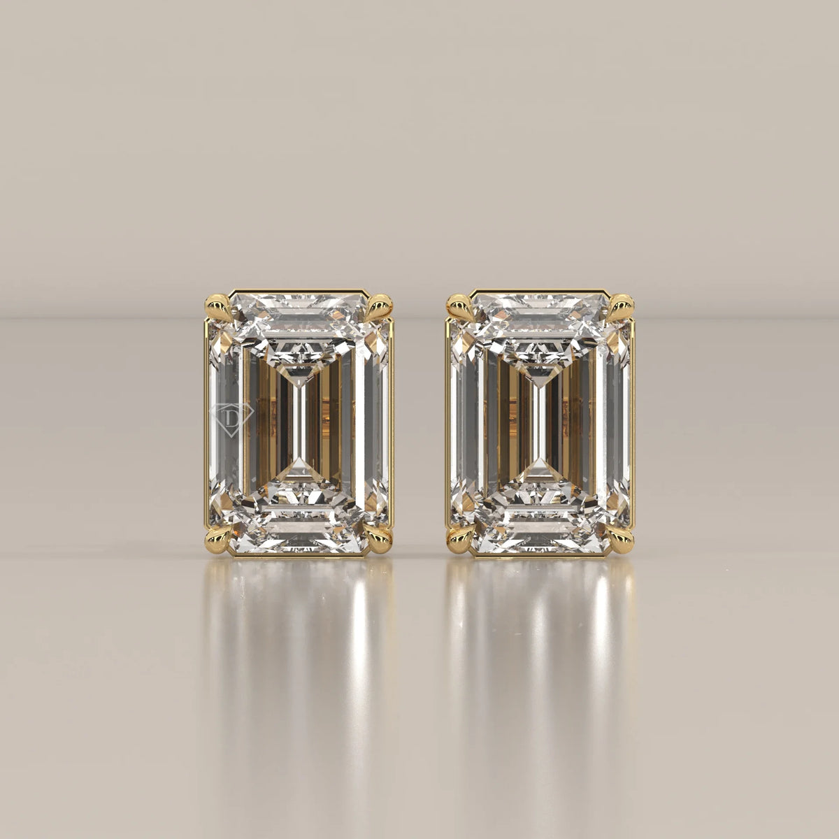 Pair of emerald cut diamond stud earrings in yellow gold.