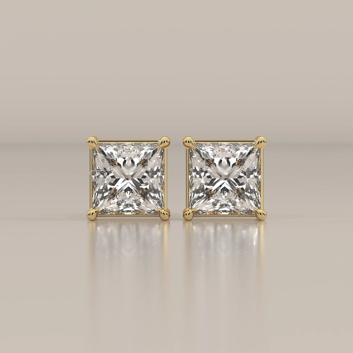 Pair of princess cut diamond stud earrings in yellow gold.