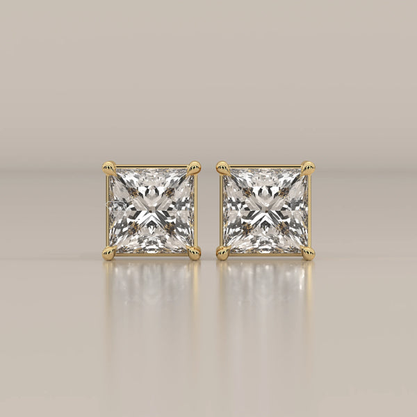 Pair of princess cut diamond stud earrings in yellow gold.