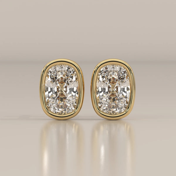 A pair of cushion-cut diamond stud earrings set in yellow gold.