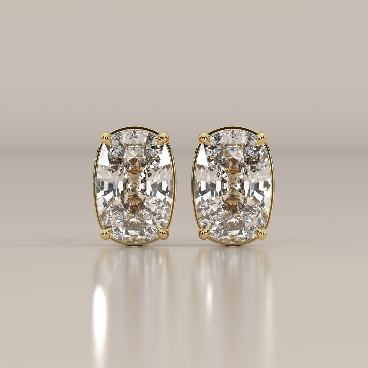 Pair of cushion-cut diamond stud earrings in yellow gold.