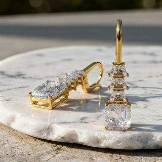 Flat-Lay: Emerald Cut Diamond Earrings with Prong Setting in 14k Yellow Gold - Lab Grown - Driona Jewels