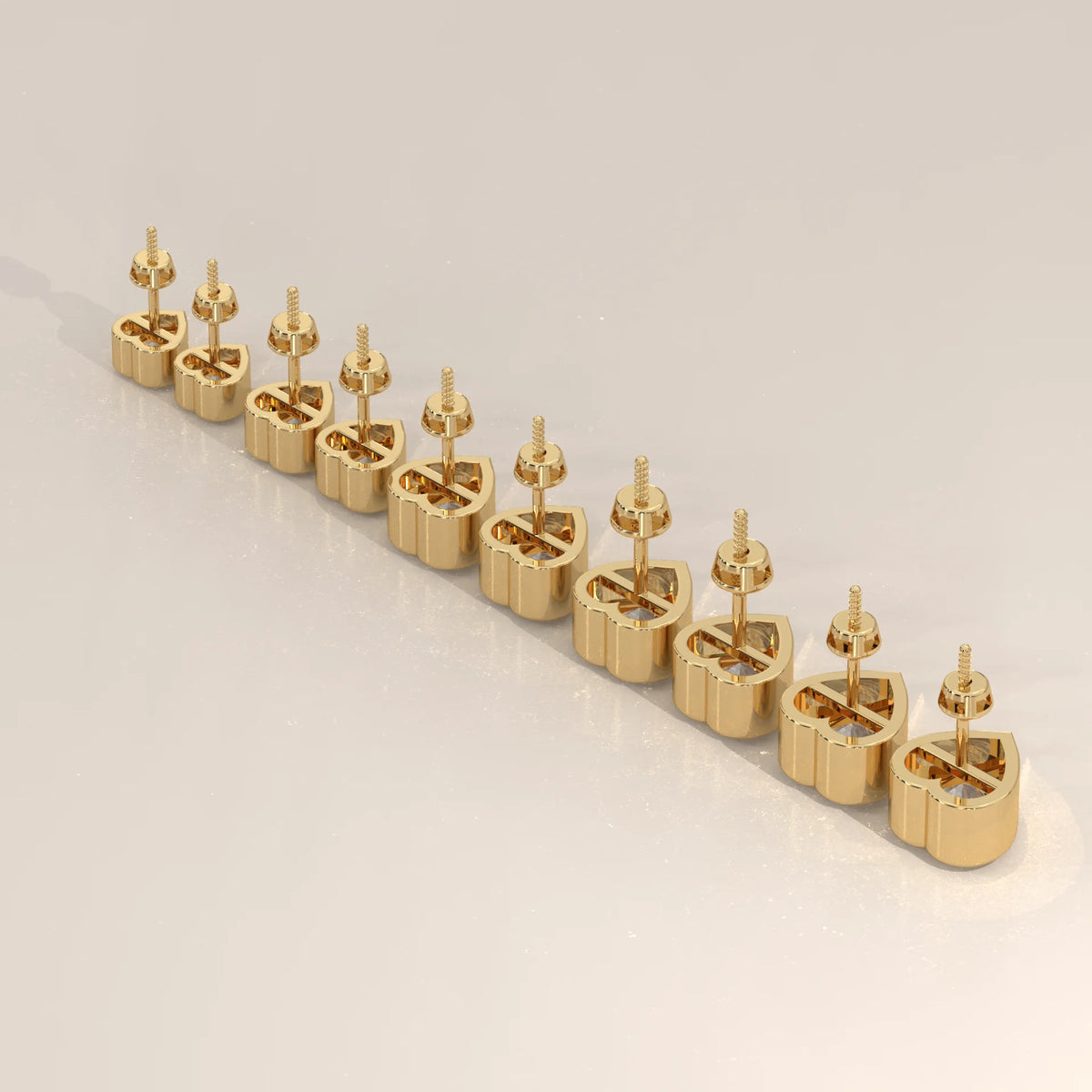 A line of small, gold heart-shaped stud earrings with screw backs, displayed diagonally.