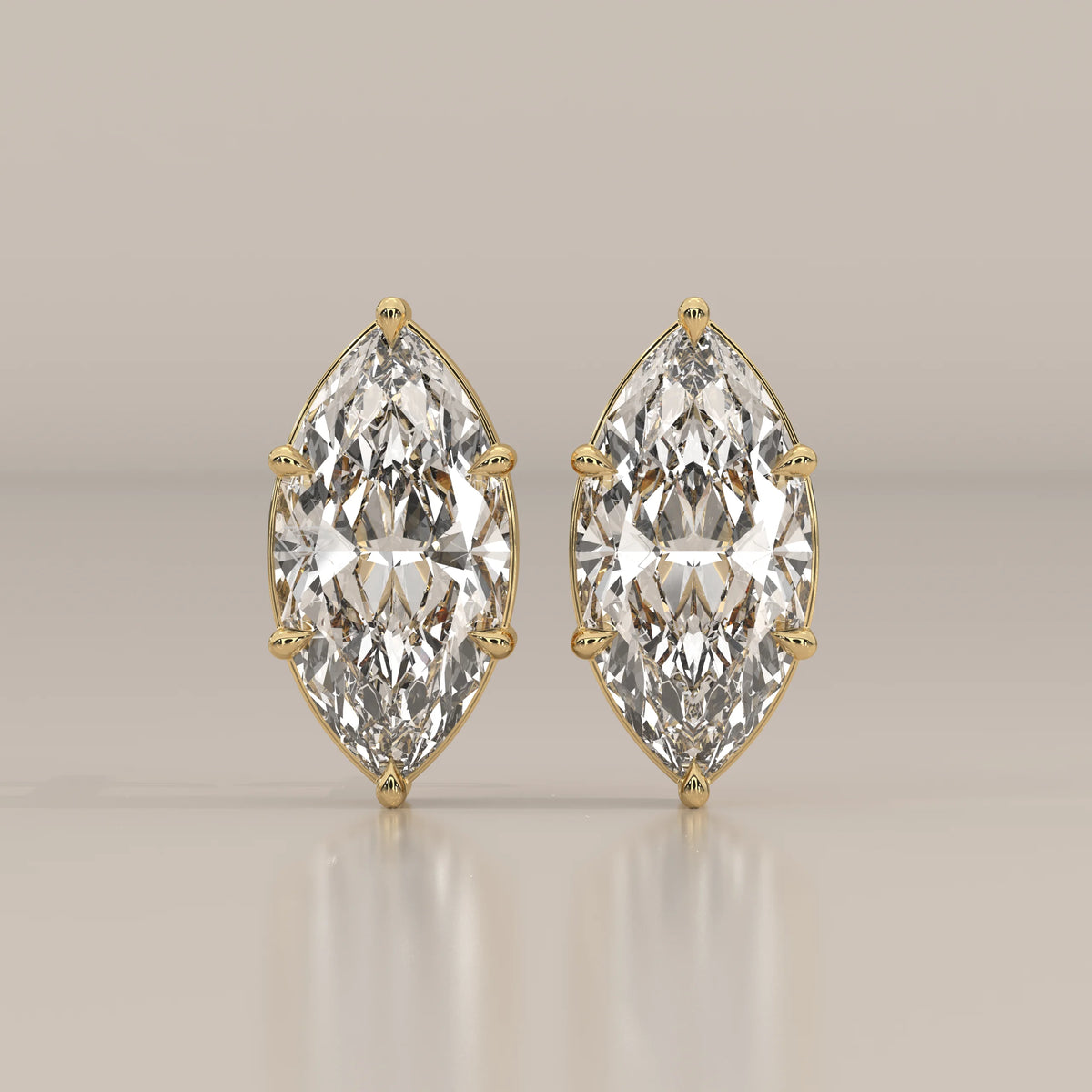 A pair of elegant 14k gold earrings featuring large marquise-cut diamonds.