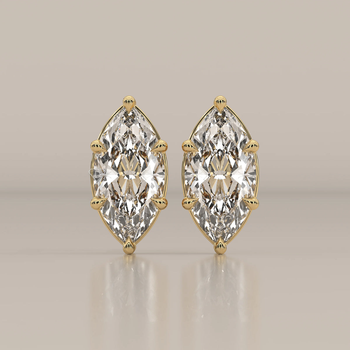 Pair of diamond stud earrings with marquise-cut stones in gold.