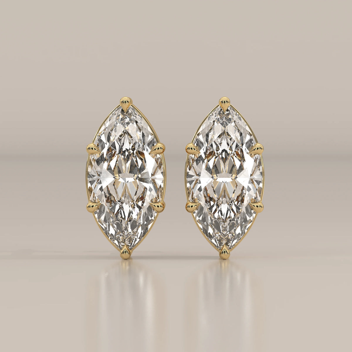 Pair of 14k gold earrings with large marquise-cut diamonds.