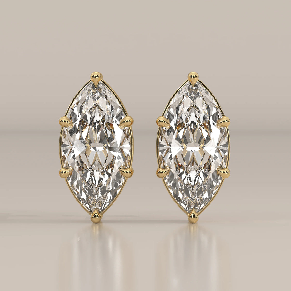 Pair of 14k yellow gold earrings featuring large marquise-cut diamonds.