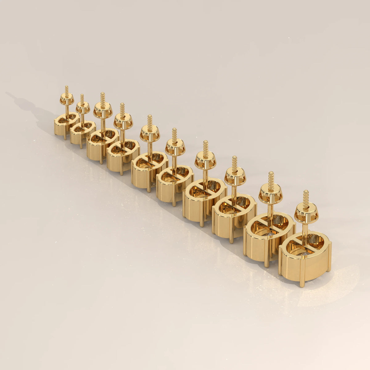 A set of ten gold oval earrings with screw backs, arranged in a diagonal line.