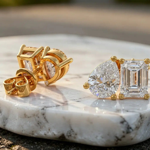 Flat Lay: Pear & Emerald Cut Diamond Earrings with Halo Setting in 14k Yellow Gold - Lab Grown - Driona Jewels