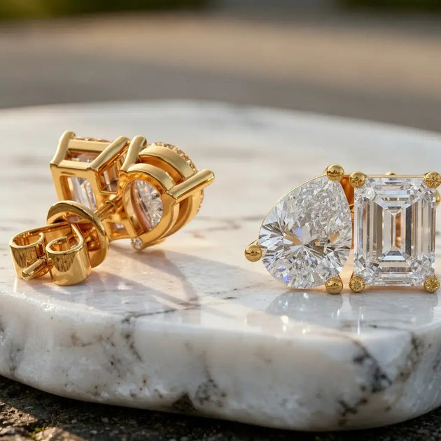 Flat Lay: Pear & Emerald Cut Diamond Earrings with Halo Setting in 14k Yellow Gold - Lab Grown - Driona Jewels
