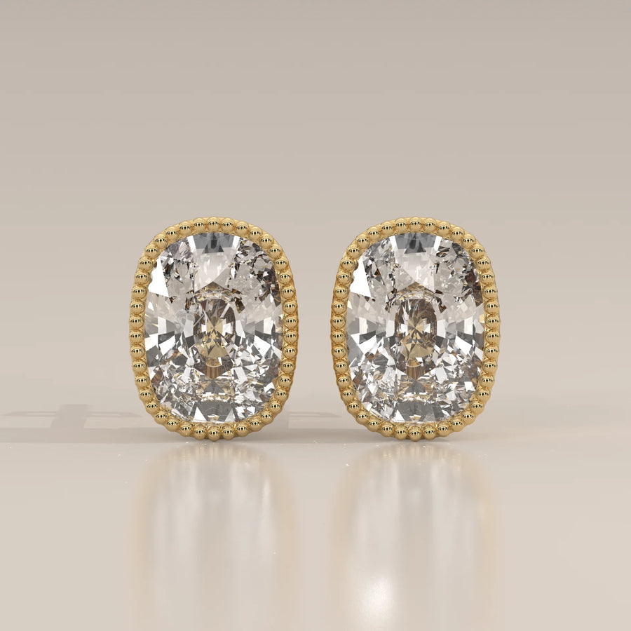 Elongated Cushion Lab Grown Diamond Studs in a Milgrain Bezel in yellow gold, shown from the front.