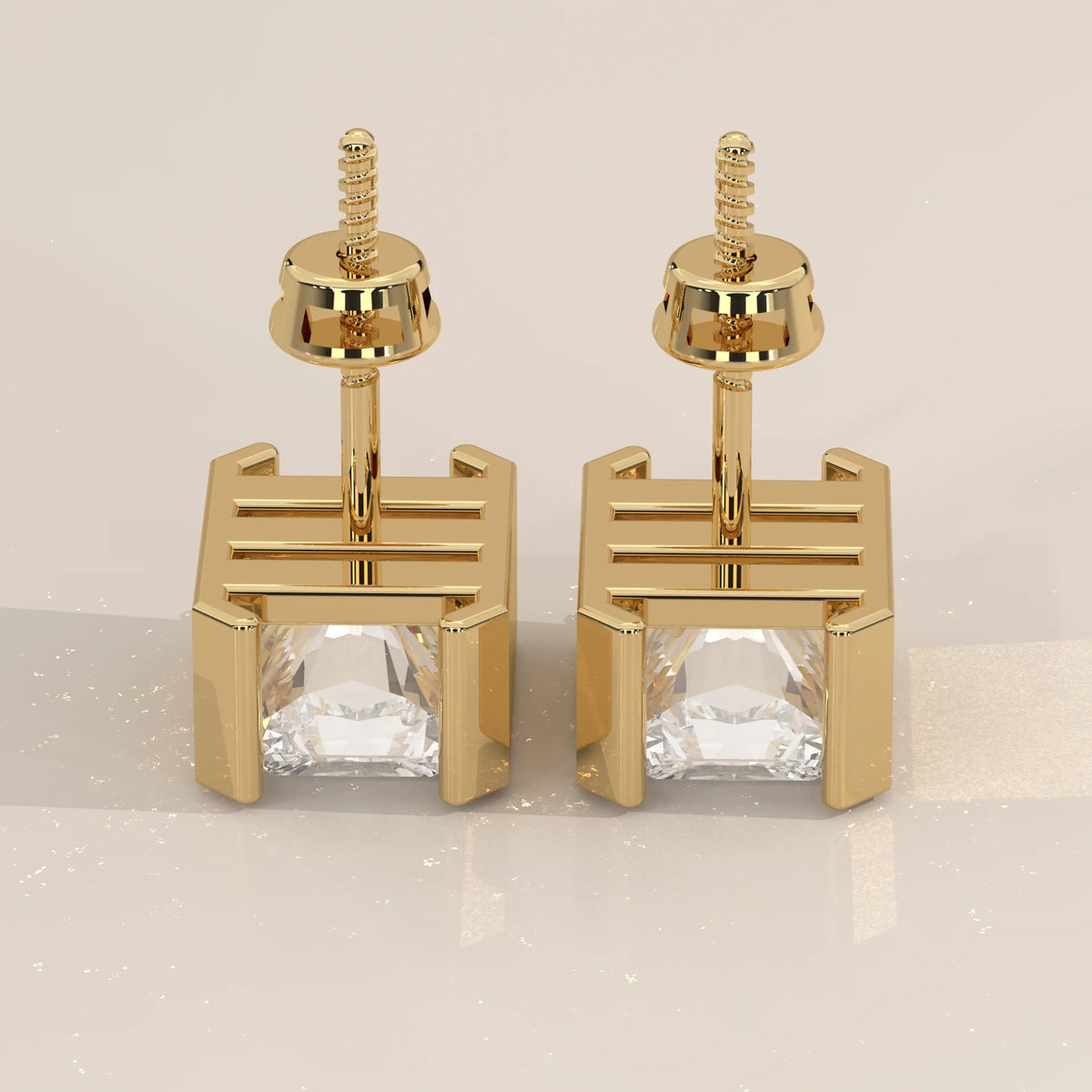 Elongated Radiant Half Bezel Lab Grown Diamond Stud Earrings in yellow gold, studio photograph on a plain background.