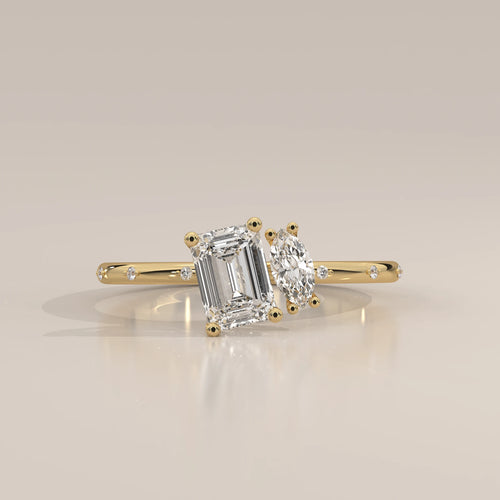 Yellow gold ring with an emerald-cut and a marquise-cut diamond.