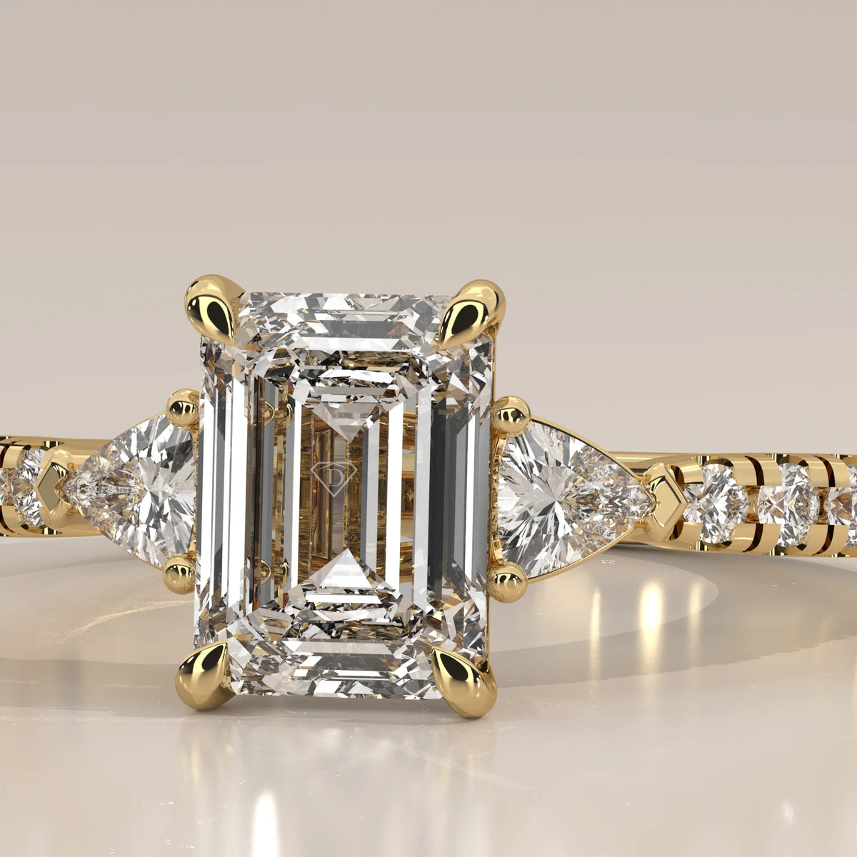 Emerald Cut Lab Grown Diamond Three Stone Ring with Trillion Sides in yellow gold, product photograph on a plain background.