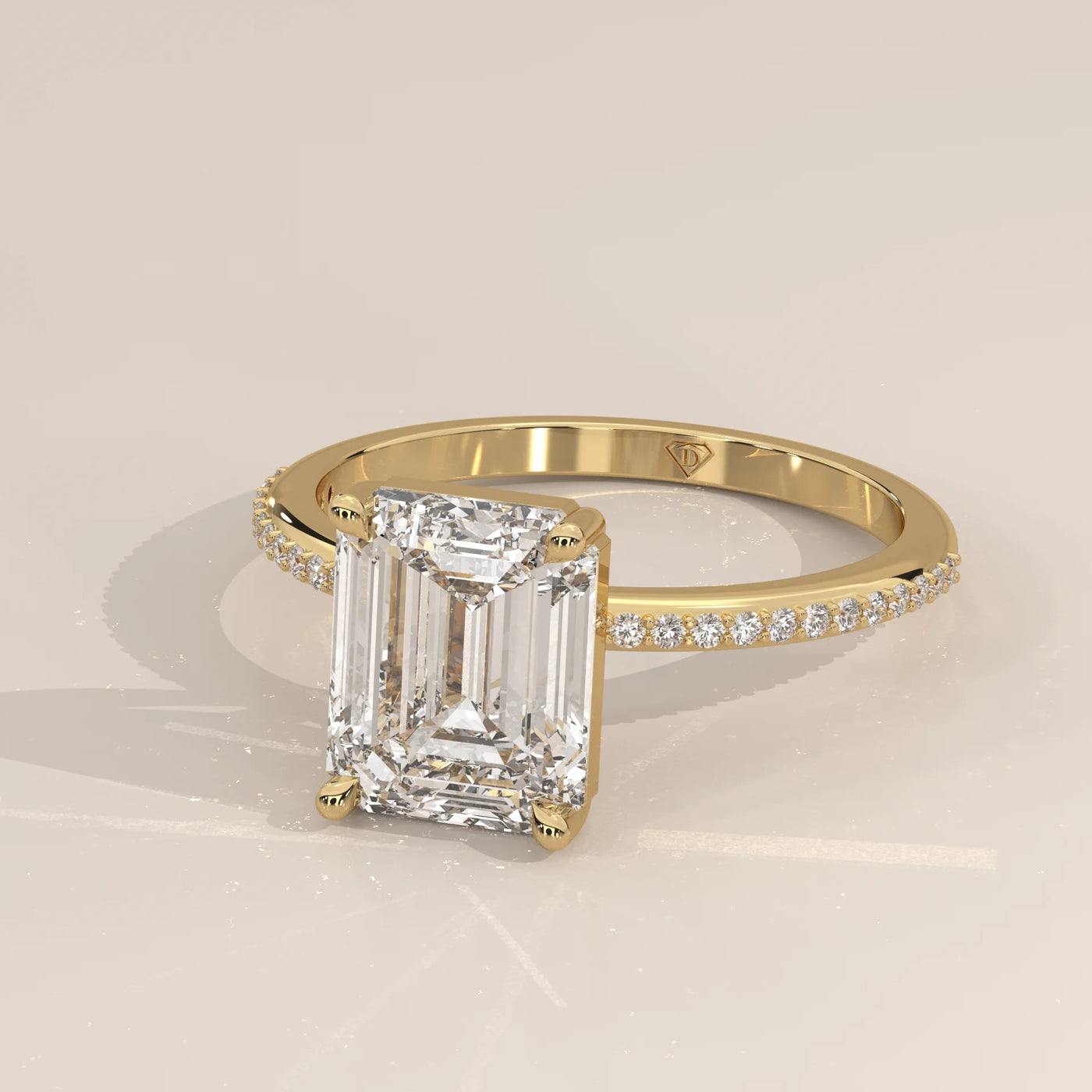 Yellow gold ring with an emerald-cut diamond and pave band.