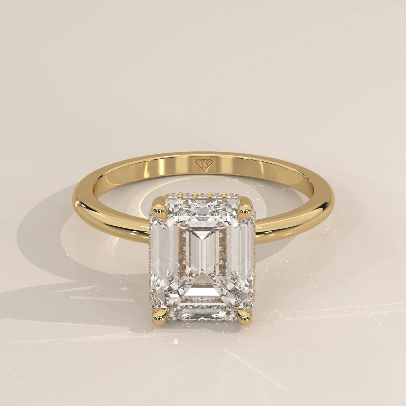 Emerald cut diamond ring with pavé band in yellow gold.
