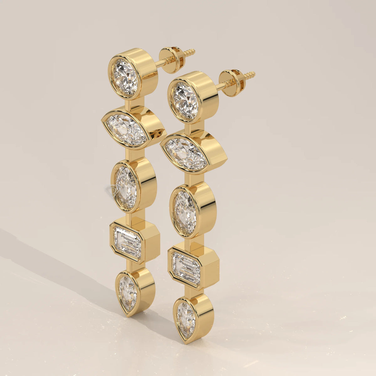 Five Shape Bezel Lab Grown Diamond Linear Drop Earrings in yellow gold, shown at an angle.