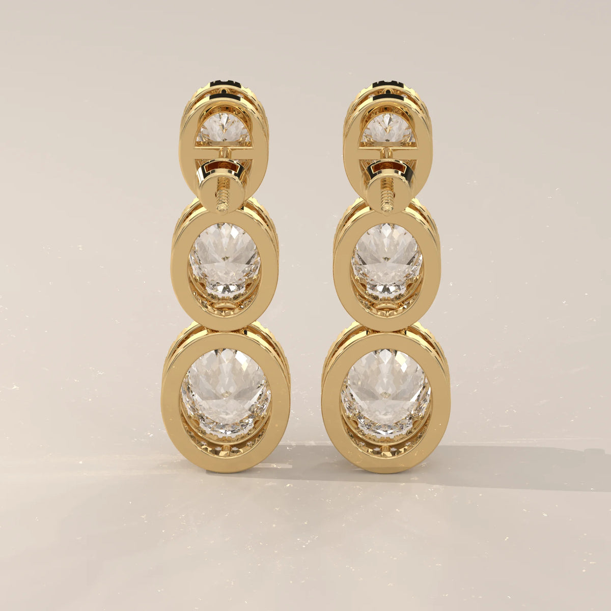 Graduated Three Oval Halo Lab Grown Diamond Drop Earrings in yellow gold, photographed head-on.