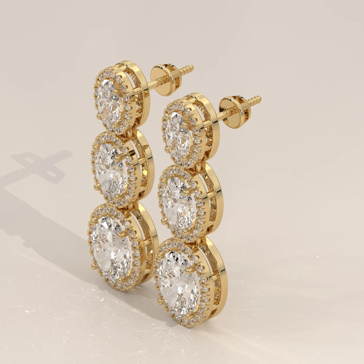 Graduated Three Oval Halo Lab Grown Diamond Drop Earrings in yellow gold, shown from the side.