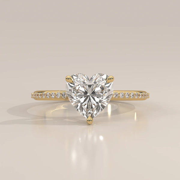 A beautiful 14k gold ring with a heart-shaped diamond and pave band.
