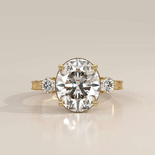 Karly 5 Carat Oval Lab Grown Diamond Three Stone Ring, Engraved Band in yellow gold, photographed head-on.