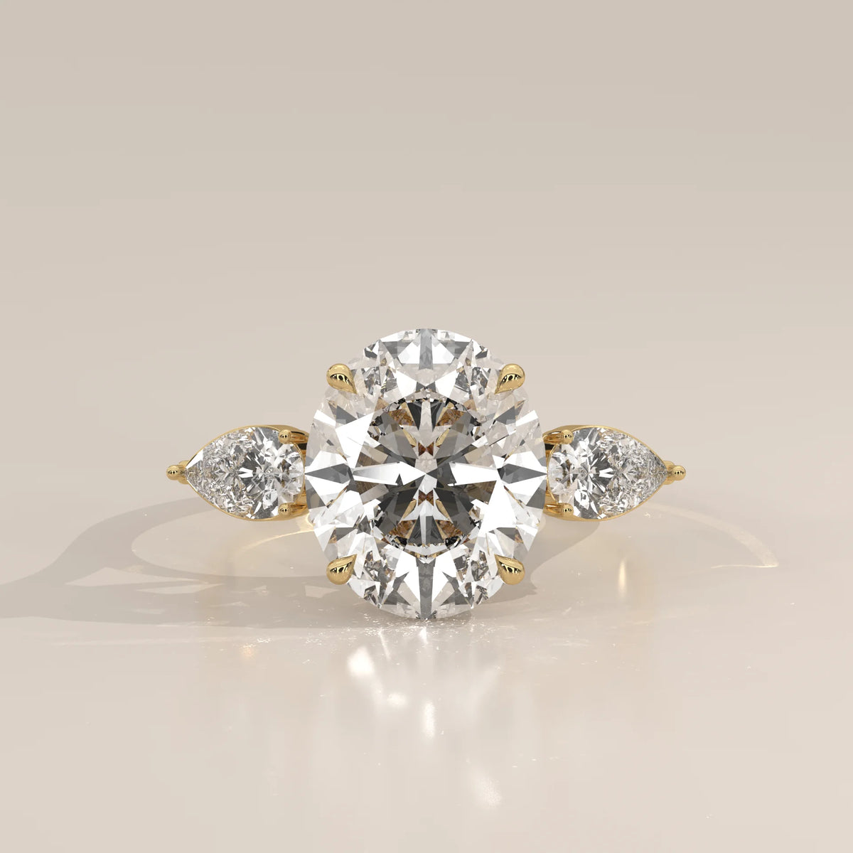 Lerrayki 5 Carat Oval Lab Grown Diamond Three Stone Ring, Pear Sides in yellow gold, photographed head-on.