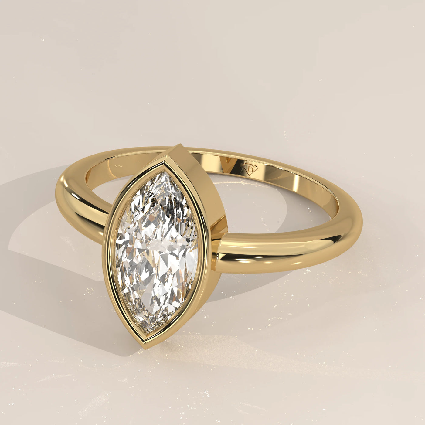 A yellow gold ring featuring a bezel-set marquise-cut diamond.